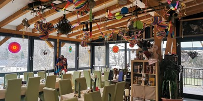 Eventlocation - Gastronomie: Essen-to-Go - Festlich geschmückter Gastraum mit Durchgang zum Balkon - AllerHand MietBar